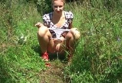 Девушка гуляя на природе присела пописать
