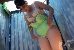 Женщина меняет в пляжной раздевалке купальник